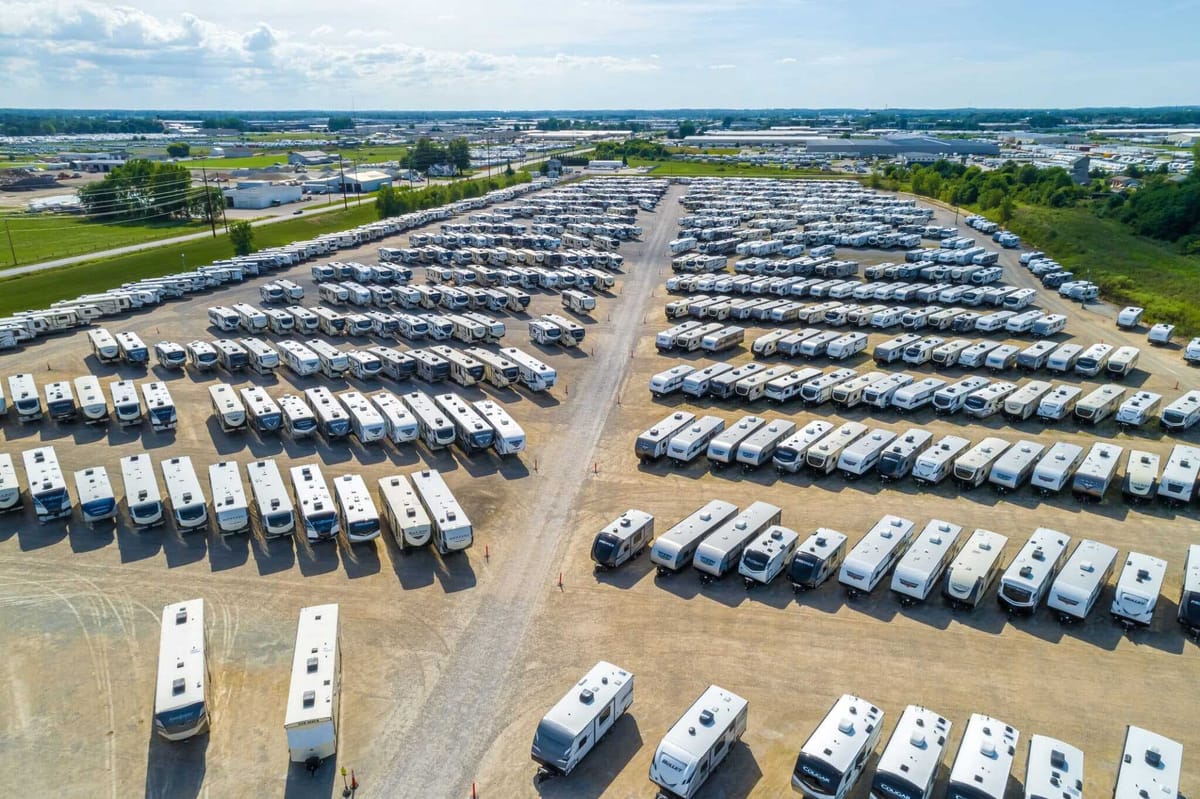 Row of RVs for sale at a dealership lot
